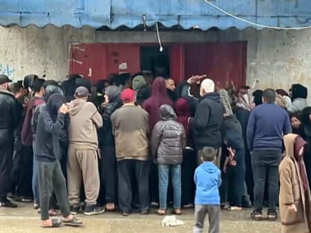 Palestinians queue for hours in pouring rain to get bread
