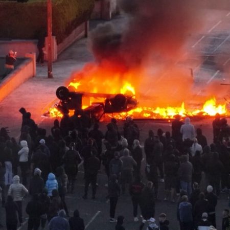 Anti-immigrant protesters clash with police, torch car at Belfast rally
